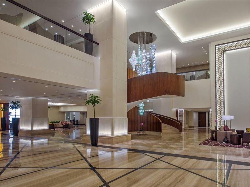Jabal Omar Hyatt Regency Makkah Hotel Mekka Kültér fotó The image shows a spacious and modern hotel lobby. It features elegant interior design with high ceilings and polished marble floors. A prominent wooden staircase with a stylish design is located in the center, leading to an upper level. There are de