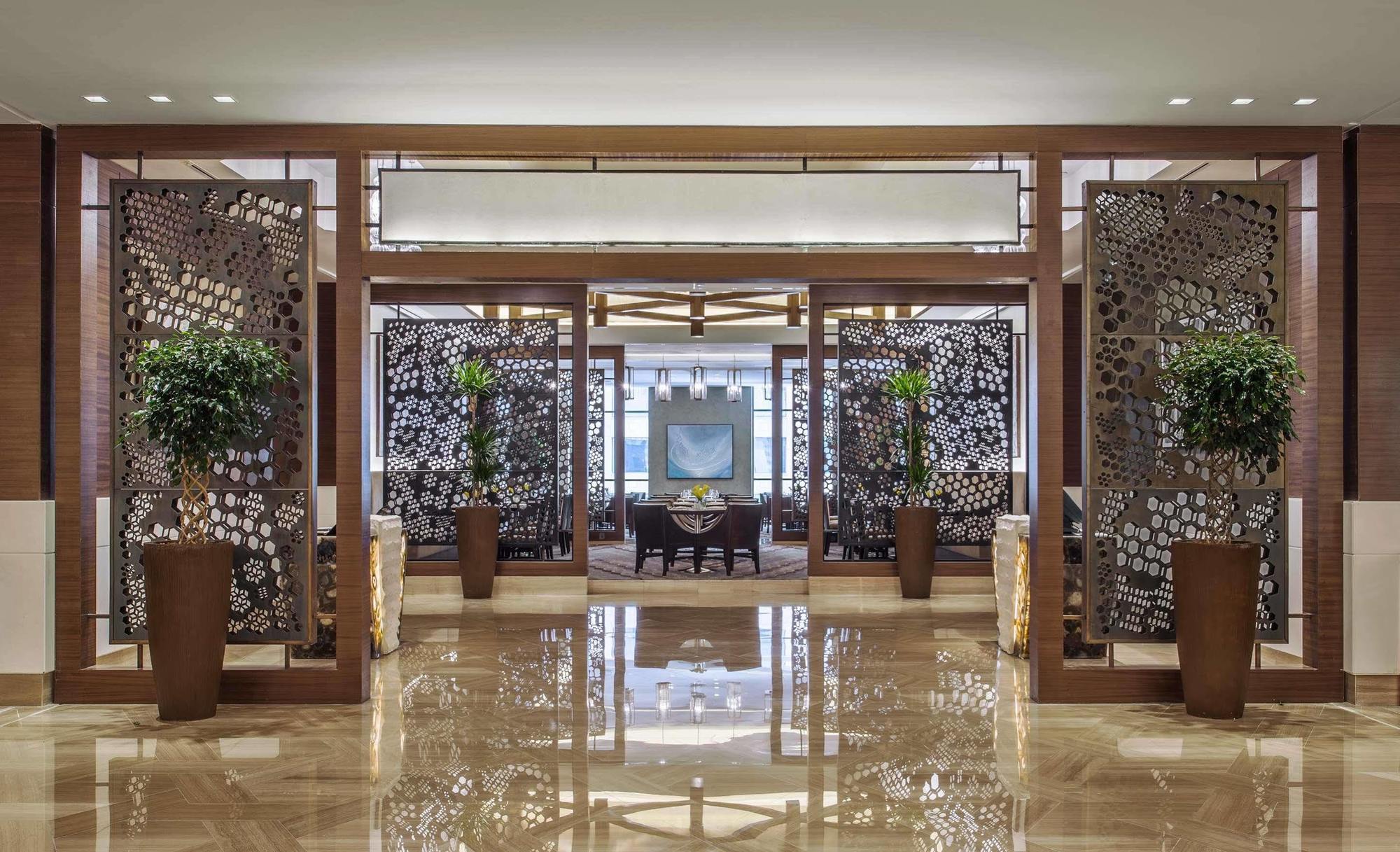 Jabal Omar Hyatt Regency Makkah Hotel Mekka Kültér fotó The image shows an elegant interior space, likely the lobby or entrance of a luxurious hotel or restaurant. The area features decorative partitions with intricate designs, framed by wooden structures. These partitions create a sense of separation whi